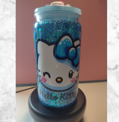 Blue glitter custom snow globe tumbler featuring a Hello Kitty design with floating sparkle and matching lid, handmade drinkware