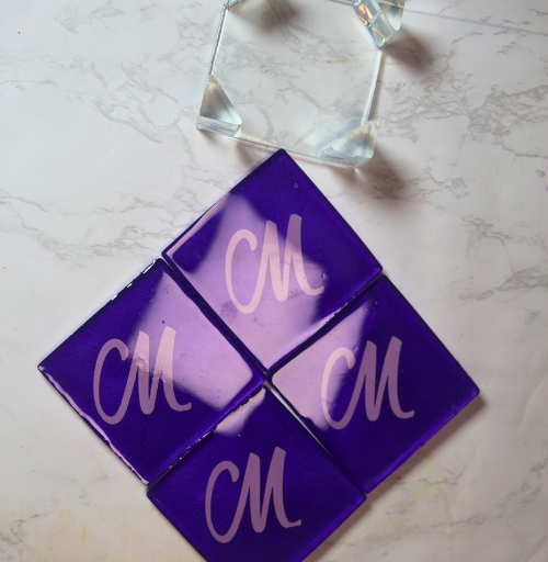 Purple handmade resin coaster set with four square coasters featuring custom initials and matching holder