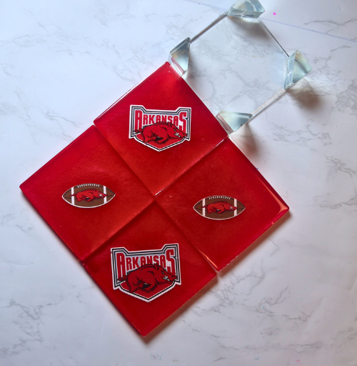 Custom red resin coaster set with four coasters and matching holder featuring sports team designs